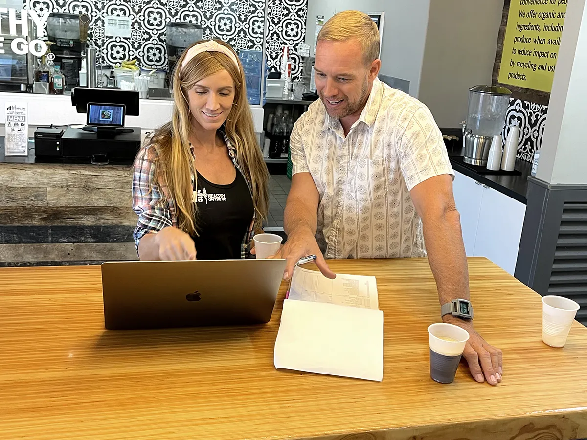 d’Lite franchise owner enjoying a smoothie and laptop